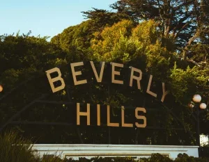 Discover the famous Beverly Hills sign amid lush greenery on a sunny day. in Beverly Hills Scavenger Hunt