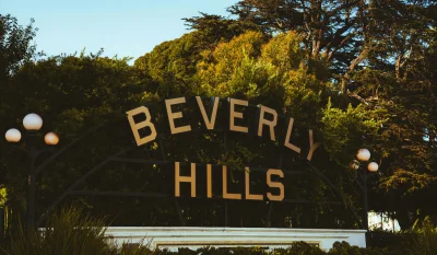 Discover the famous Beverly Hills sign amid lush greenery on a sunny day. in Beverly Hills Scavenger Hunt