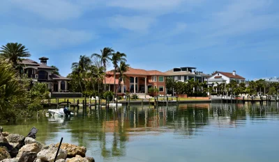Scenic view of luxury homes along the Sarasota waterfront, surrounded by palm trees and calm waters. in Sarasota Scavenger Hunt, FL