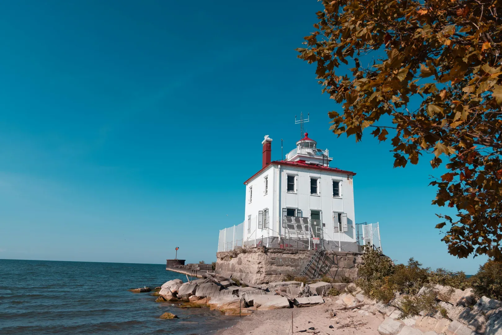 A historic lighthouse on Lake Erie's coast captures the essence of autumn under a clear blue sky. in Erie Scavenger Hunt, PA