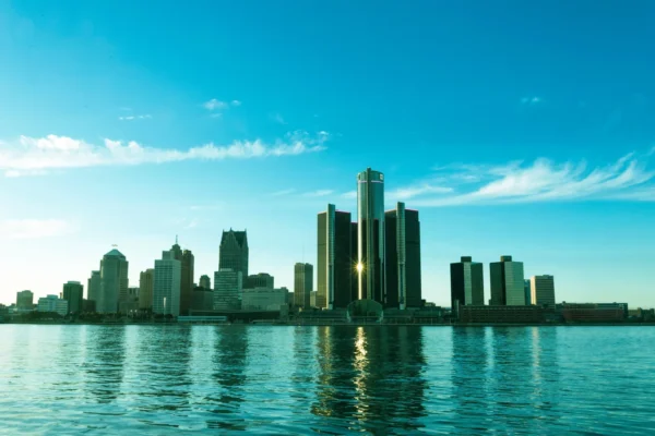A beautiful view of the Detroit skyline reflecting on the river at sunrise, showcasing modern skyscrapers. in Detroit Scavenger Hunt, MI