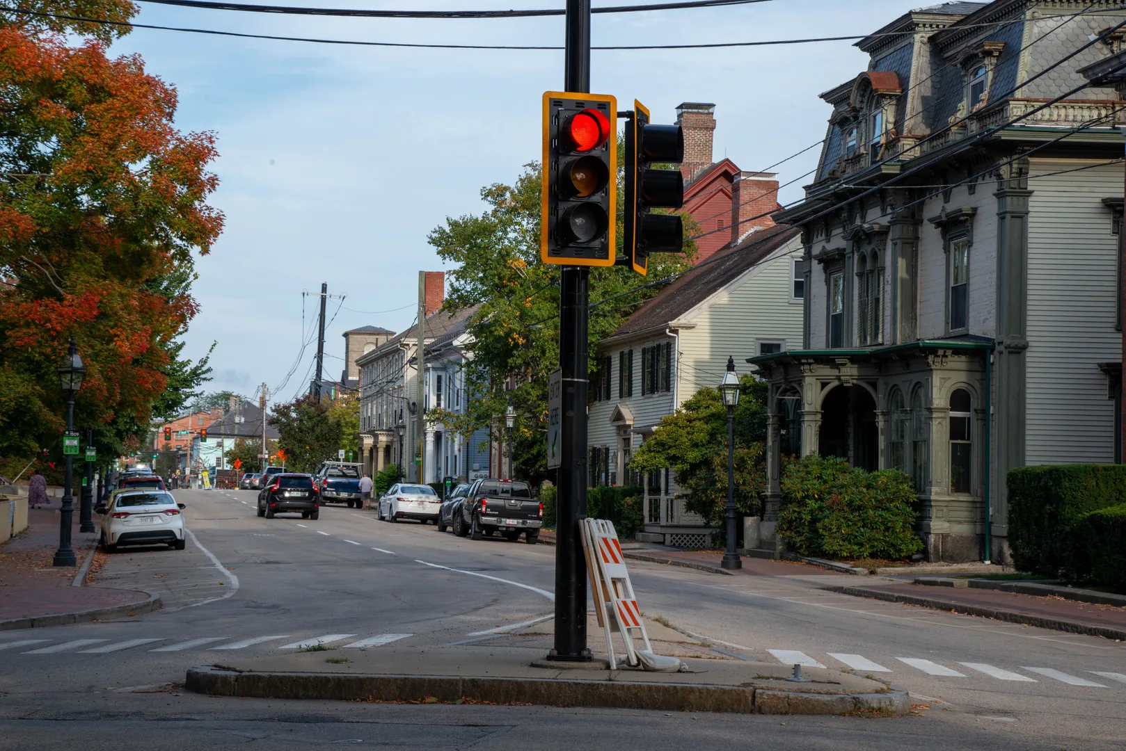 Street view in Portsmouth, NH, showcasing historic homes and a red traffic light on a sunny day. in Portsmouth New Hampshire Scavenger Hunt, NH