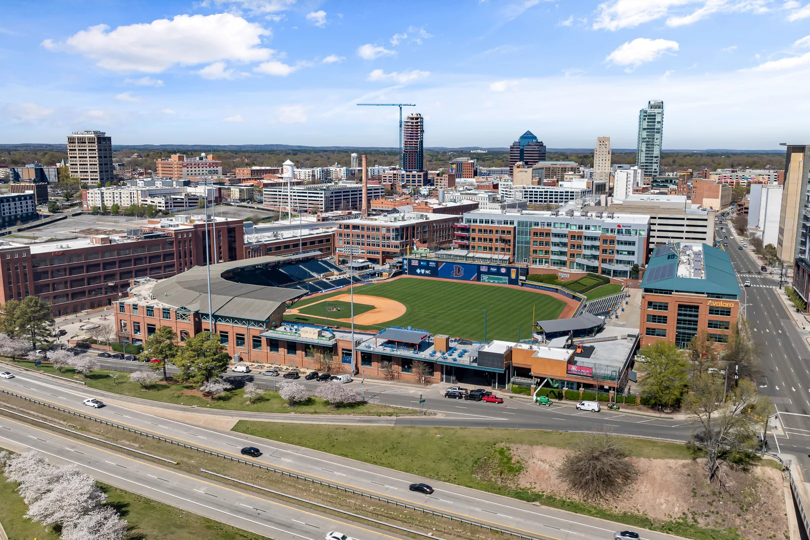 Aerial shot of Durham Bulls Athletic Park with city skyline in springtime. in Durham Scavenger Hunt, NC