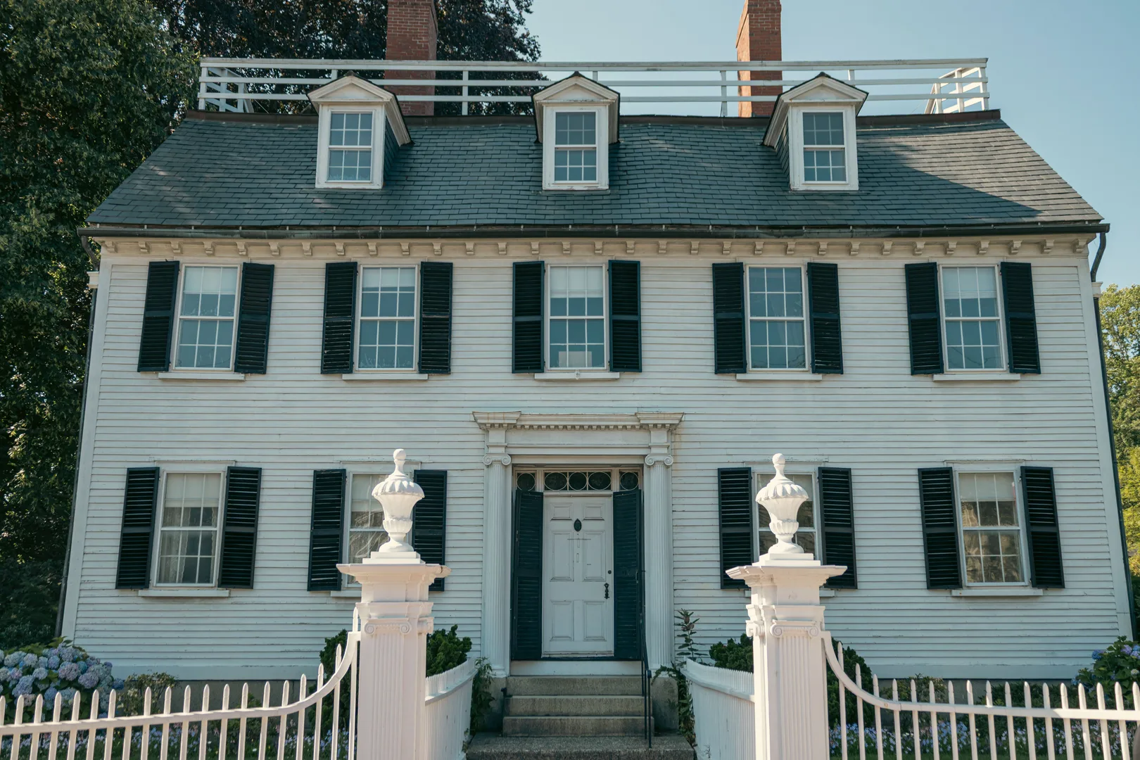 Elegant Colonial-style house with black shutters and white picket fence in Salem, Massachusetts. in Salem Massachusetts Scavenger Hunt