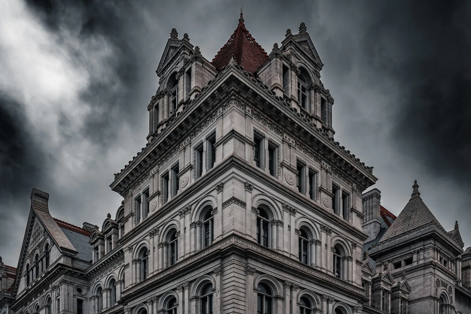 Dramatic view of the New York State Capitol building's Neo-Renaissance facade under stormy skies. in Albany New York Scavenger Hunt