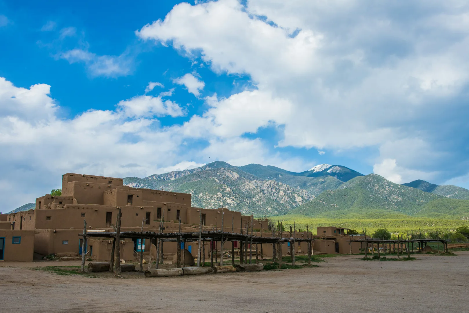 a large adobe building with mountains in the background in Taos Scavenger Hunt, NM