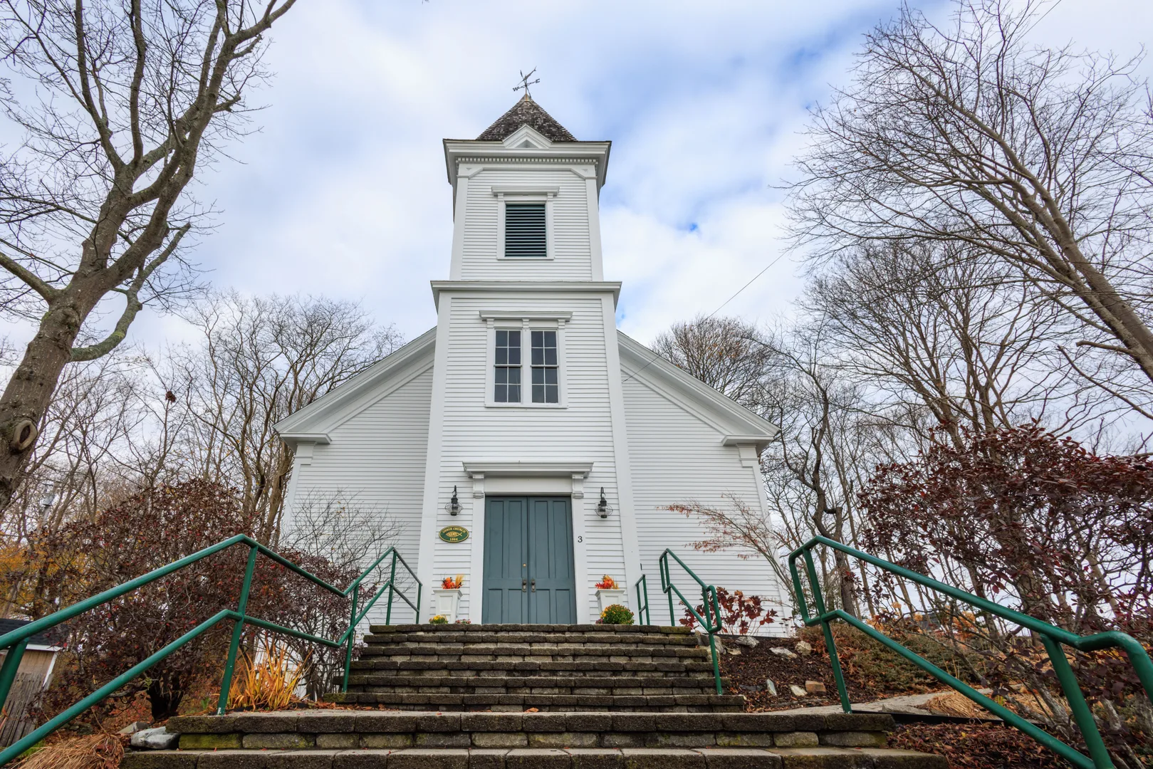 A beautiful white church in Biddeford, Maine, surrounded by bare trees and autumn foliage. in Biddeford Scavenger Hunt, ME