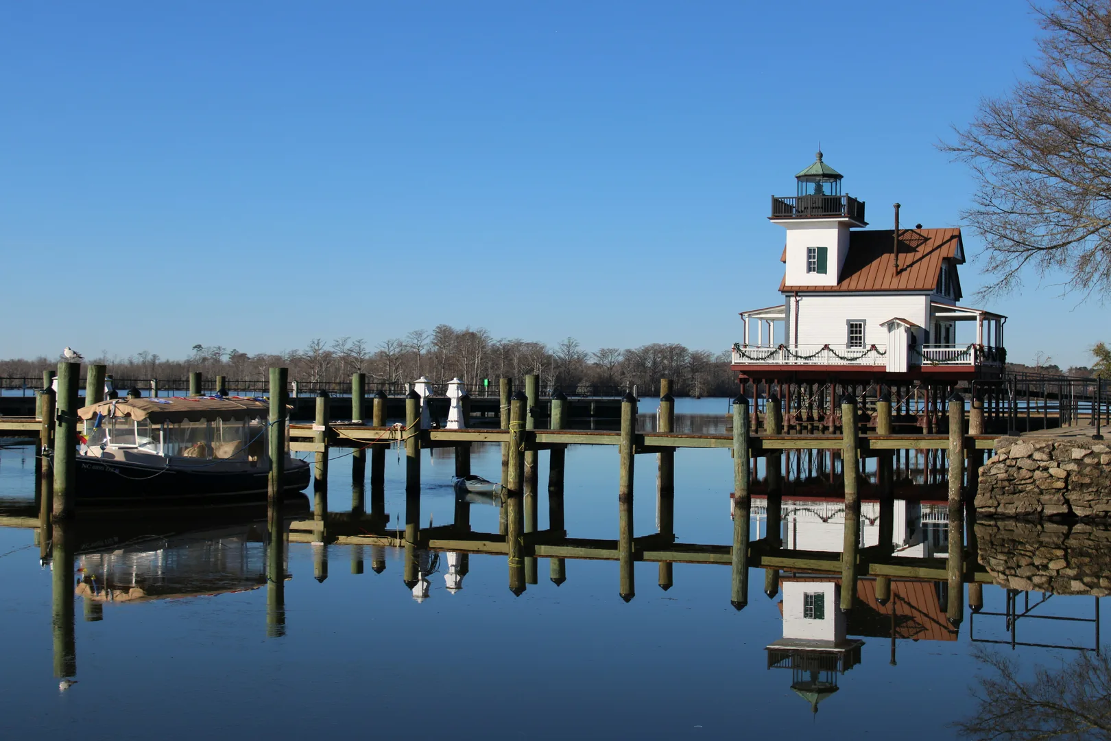 a boat is docked at a pier on a clear day in Edenton Scavenger Hunt, NC