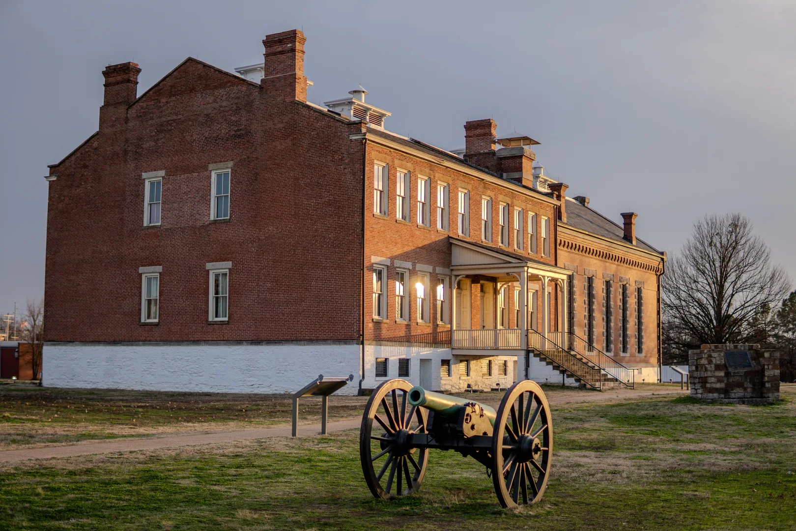 A historical cannon in front of a brick building at Fort Smith, Arkansas, during sunset. in Fort Smith Scavenger Hunt, AR